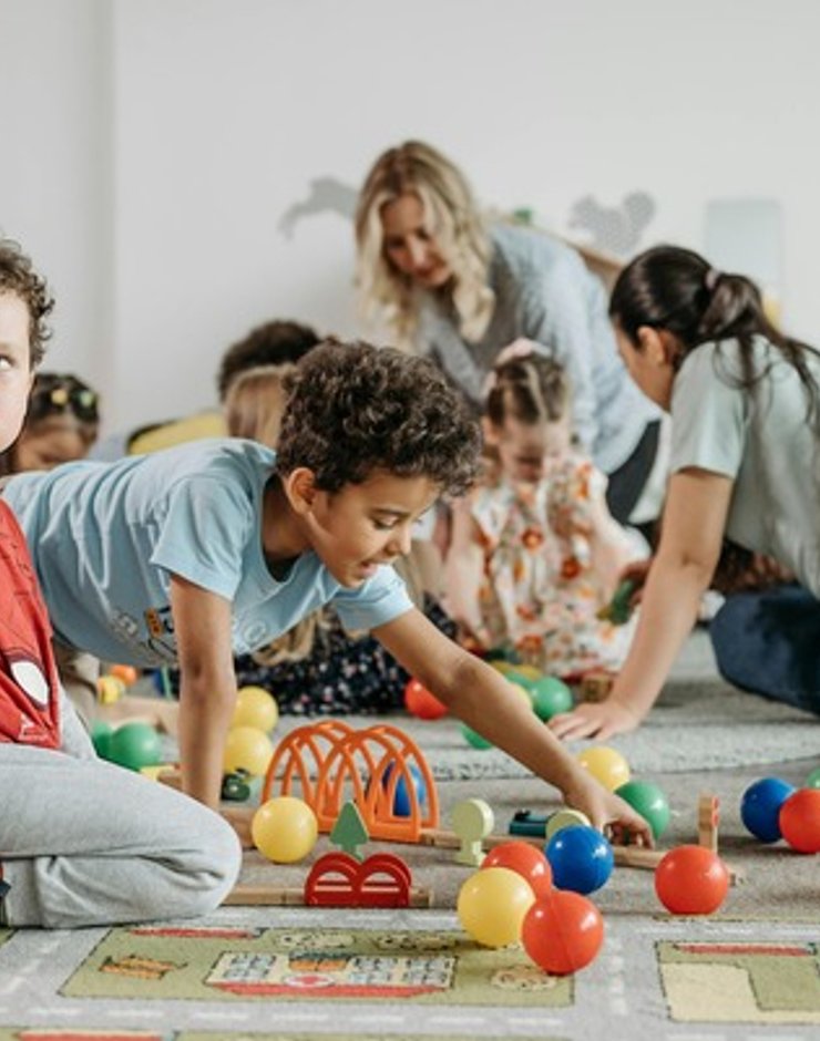 Children learning and playing with teachers in a Lakewood daycare classroom.