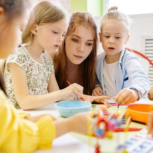 Children painting together in a daycare activity.
