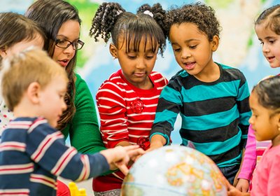 Teacher guiding children in a group activity during extended-hours child care