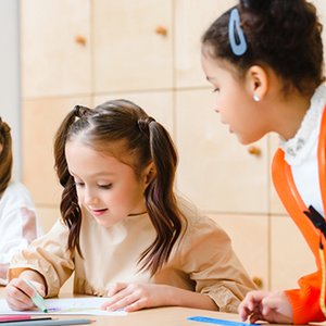 School-age children focused on writing and classroom work.