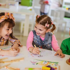 Preschool children working together on drawing activities.