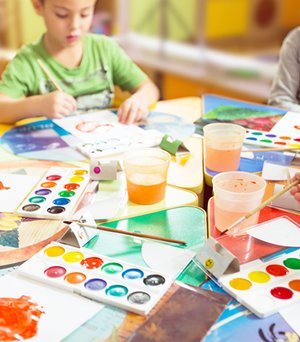 Preschoolers painting and creating art during class.