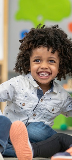 Child smiling during an afternoon classroom session.