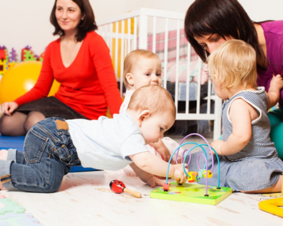 Infant practicing movement and sensory play in a safe classroom.